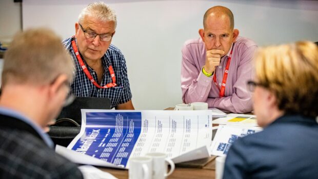 A small table at Transforming Together in Cardiff working on the 7 Lenses Maturity Matrix